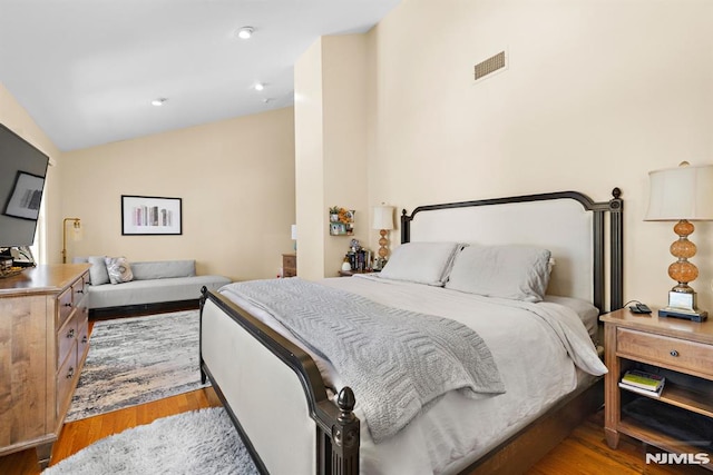 bedroom featuring vaulted ceiling, visible vents, light wood-style flooring, and recessed lighting