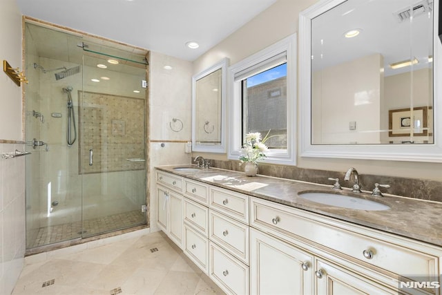 full bathroom featuring double vanity, a sink, visible vents, and a shower stall