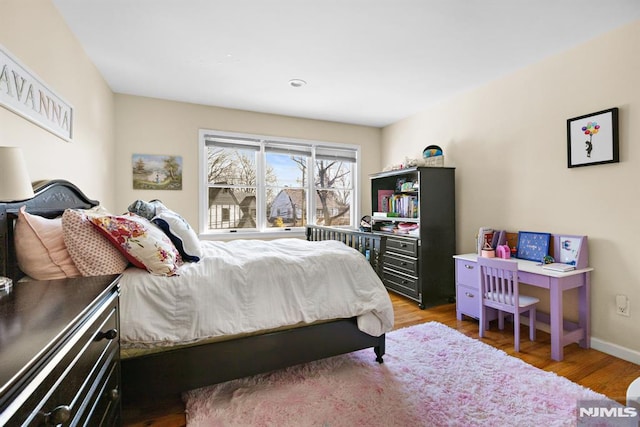 bedroom featuring wood finished floors and baseboards