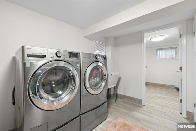 laundry room featuring washer and dryer, laundry area, and light wood finished floors