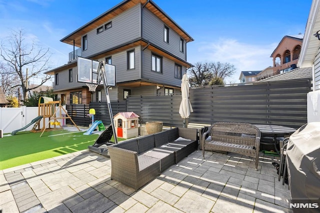 back of property with a patio area, a playground, a fenced backyard, and an outdoor living space