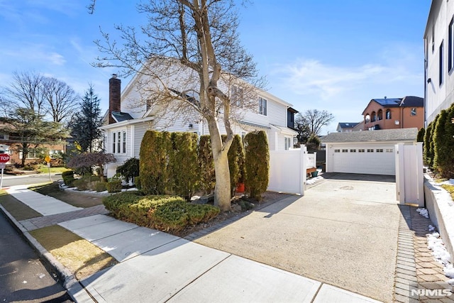 view of side of home with a garage, a residential view, and fence