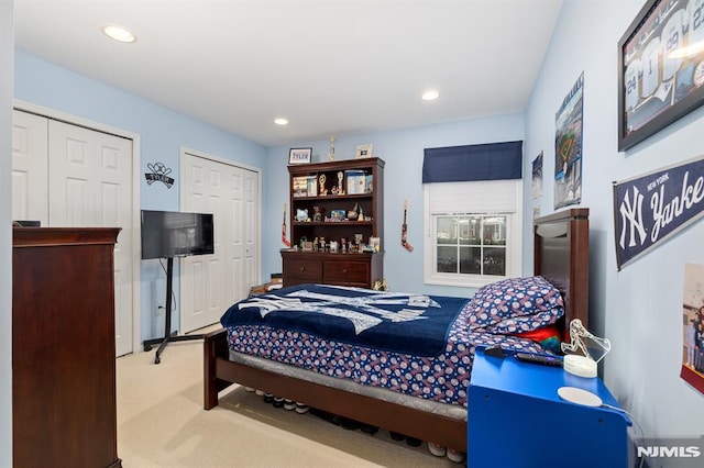 bedroom featuring carpet floors and two closets