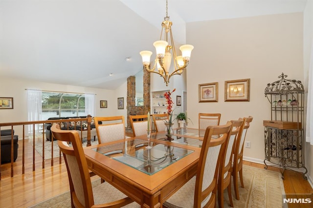 dining area featuring an inviting chandelier, high vaulted ceiling, and light hardwood / wood-style floors