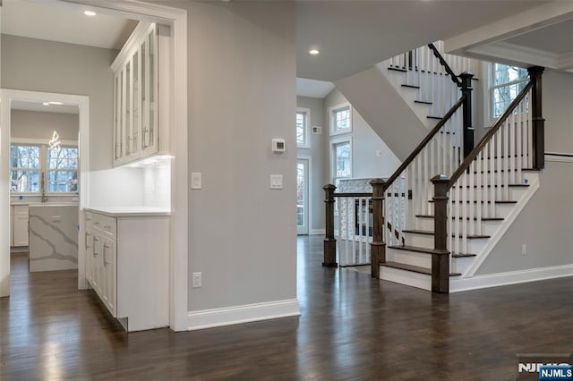 staircase with hardwood / wood-style floors, a healthy amount of sunlight, and a high ceiling