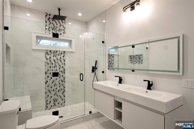 bathroom featuring walk in shower, vanity, and toilet