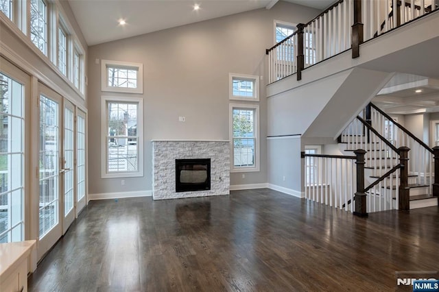 unfurnished living room with dark hardwood / wood-style flooring, a fireplace, and high vaulted ceiling