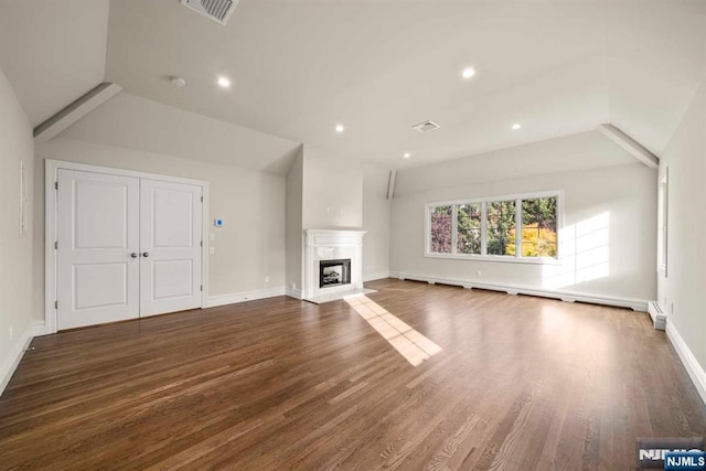 unfurnished living room with lofted ceiling, dark wood-type flooring, a high end fireplace, and baseboard heating