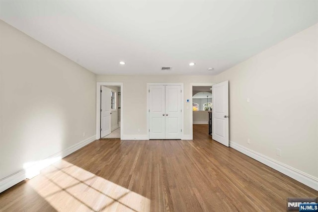 unfurnished bedroom with light hardwood / wood-style floors and a closet