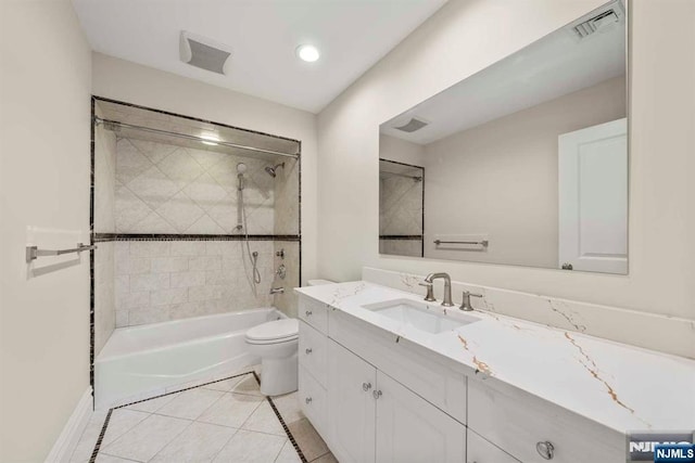 full bathroom with vanity, tiled shower / bath combo, tile patterned floors, and toilet