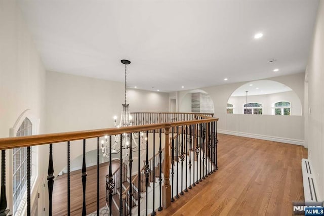 hallway featuring a chandelier and light hardwood / wood-style flooring