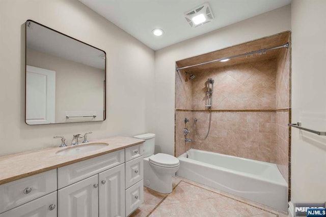 full bathroom with tiled shower / bath, vanity, tile patterned floors, and toilet