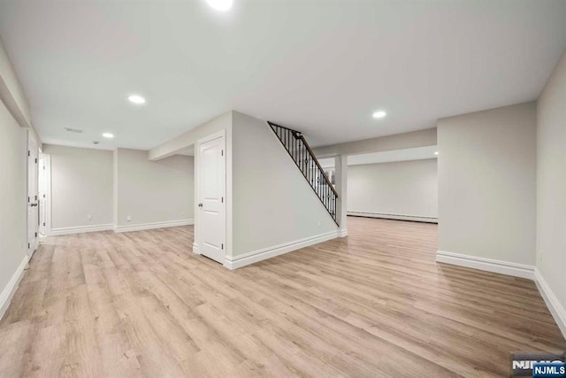 basement with a baseboard radiator and light wood-type flooring