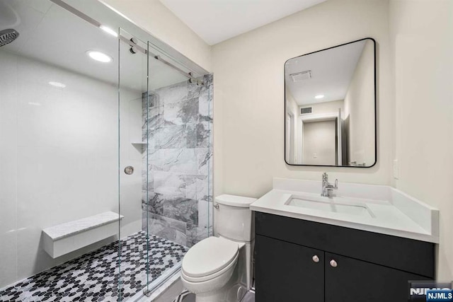 bathroom featuring vanity, toilet, and tiled shower