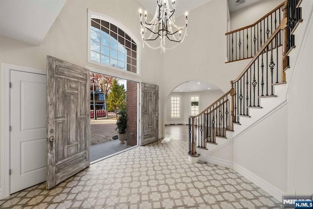 foyer with a towering ceiling and a notable chandelier