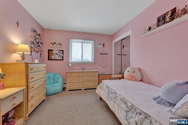 bedroom with a baseboard radiator, light colored carpet, and a closet