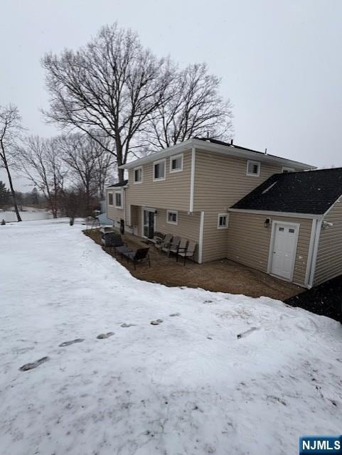 view of snow covered rear of property