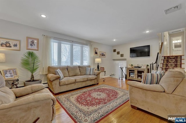 living room with light hardwood / wood-style flooring and a baseboard heating unit