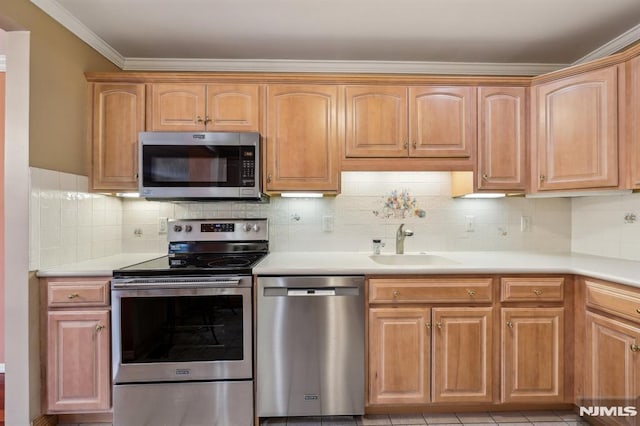 kitchen featuring decorative backsplash, appliances with stainless steel finishes, light countertops, crown molding, and a sink