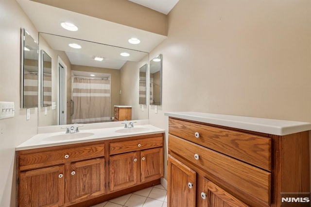 full bath with double vanity, a sink, a shower with shower curtain, and tile patterned floors