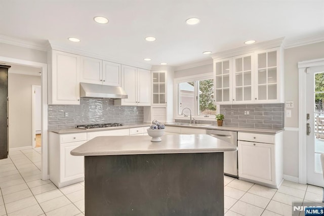 kitchen with stainless steel appliances, white cabinets, a kitchen island, and crown molding