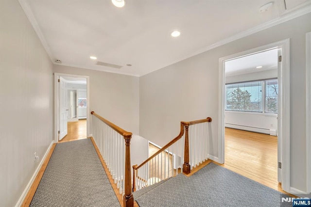 corridor featuring ornamental molding, a baseboard heating unit, and light hardwood / wood-style flooring