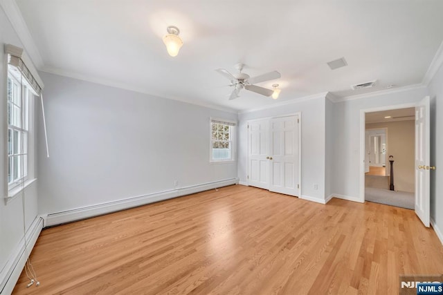 unfurnished bedroom with a baseboard heating unit, ornamental molding, and light wood-type flooring