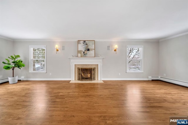 unfurnished living room with a healthy amount of sunlight, crown molding, and hardwood / wood-style floors