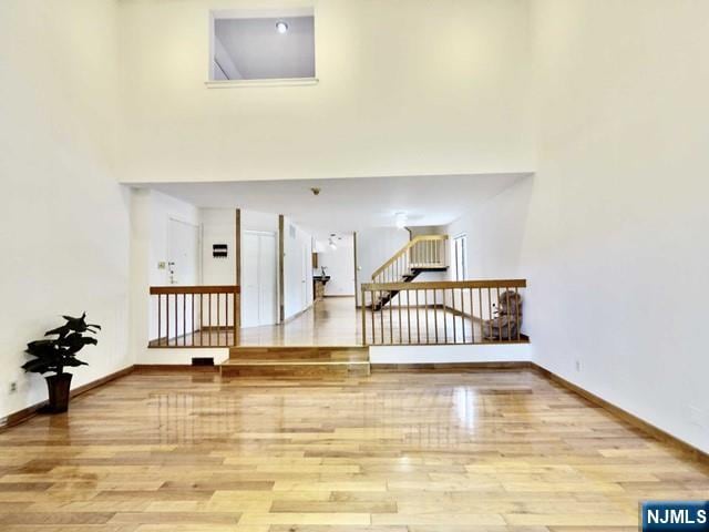 interior space featuring light hardwood / wood-style floors and a high ceiling