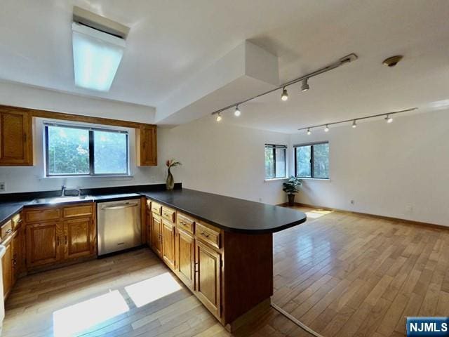 kitchen featuring a healthy amount of sunlight, dishwasher, kitchen peninsula, and light wood-type flooring