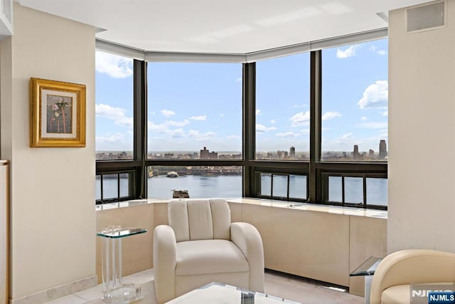 living area with a water view, a wall of windows, and a wealth of natural light