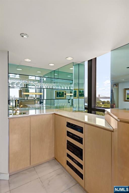 bar with sink and light brown cabinets