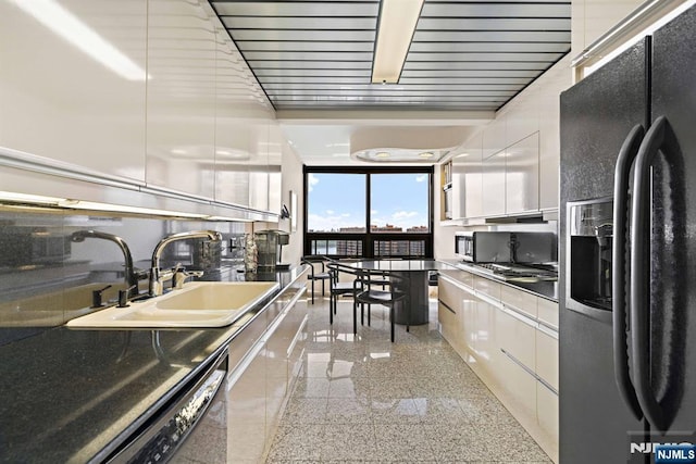 kitchen with white cabinetry, sink, and black appliances