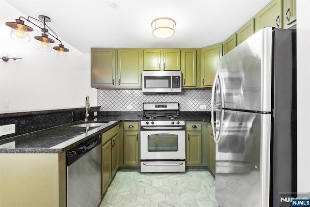 kitchen with sink, green cabinets, stainless steel appliances, tasteful backsplash, and dark stone counters