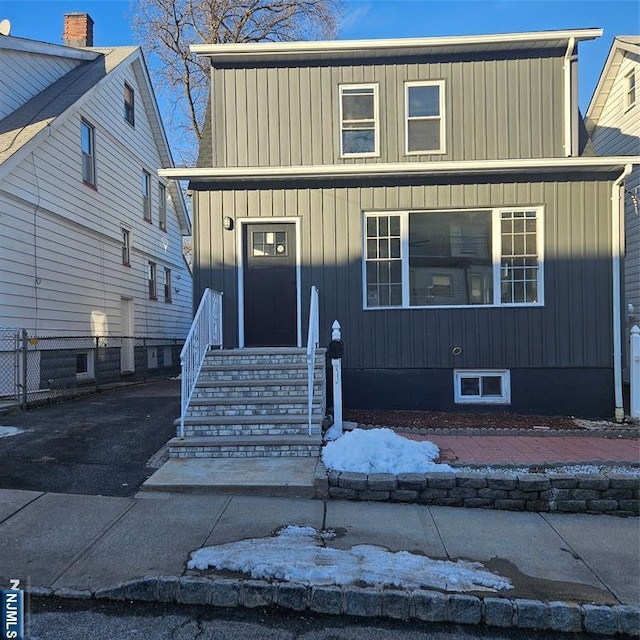 traditional-style home with board and batten siding and fence