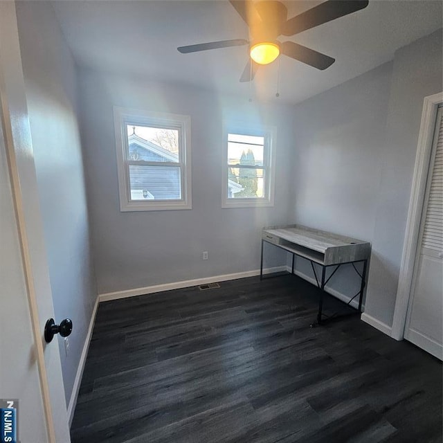 spare room with dark wood-type flooring and ceiling fan