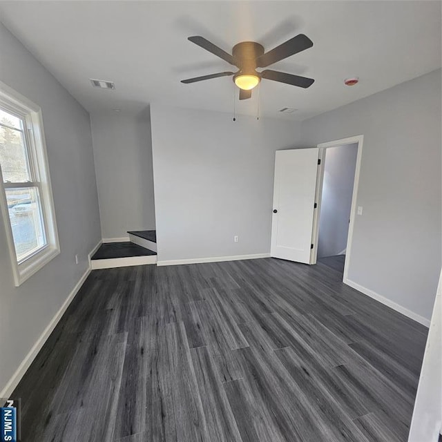 spare room with dark hardwood / wood-style floors and ceiling fan