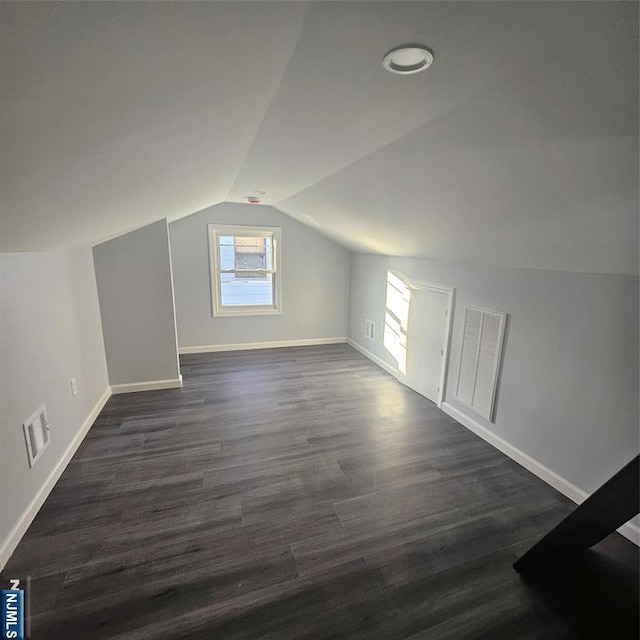 bonus room featuring dark wood-type flooring and vaulted ceiling