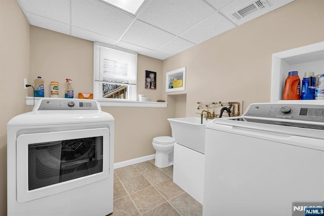 laundry room with light tile patterned floors, laundry area, visible vents, baseboards, and washing machine and clothes dryer