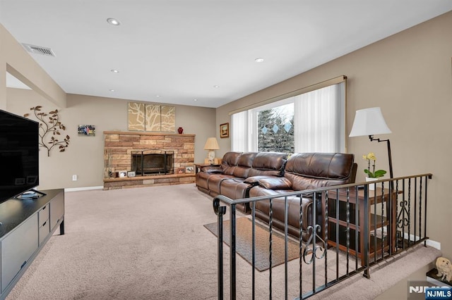 living area with carpet, recessed lighting, visible vents, a stone fireplace, and baseboards