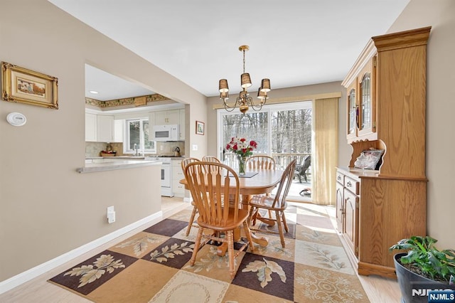 dining space with a chandelier and baseboards