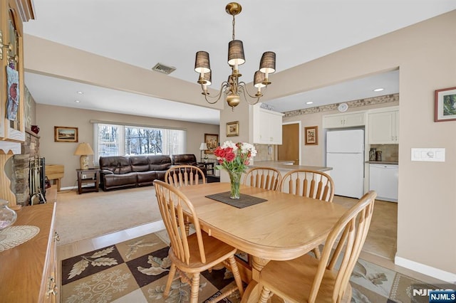 carpeted dining room featuring baseboards, recessed lighting, visible vents, and an inviting chandelier