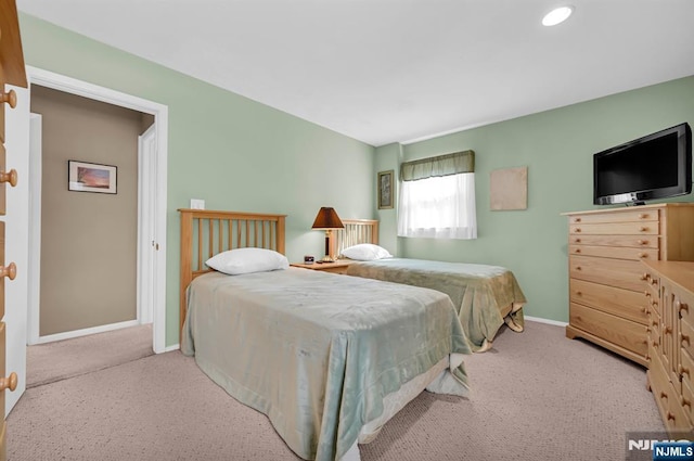 bedroom featuring light carpet and baseboards