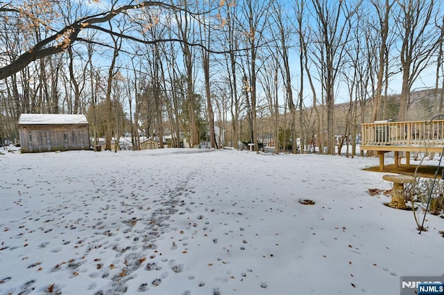 yard covered in snow with a deck