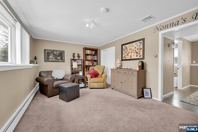 living area with carpet, a healthy amount of sunlight, visible vents, and baseboard heating