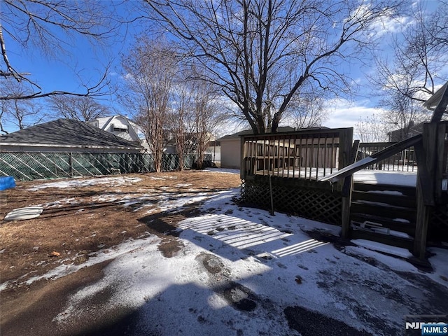 snowy yard with a wooden deck