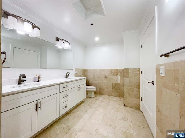 bathroom with tile walls, vanity, crown molding, and toilet