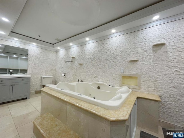 bathroom with tile patterned floors, toilet, vanity, and tiled bath