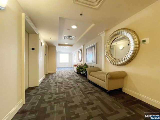 hall with elevator and dark colored carpet