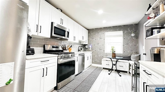 kitchen featuring tasteful backsplash, appliances with stainless steel finishes, sink, and white cabinets